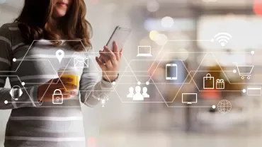 Persona usando un smartphone con iconos digitales flotando alrededor.