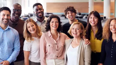 Grupo de personas sonriendo en una oficina moderna.