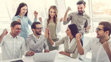 Grupo de personas celebrando en una oficina.