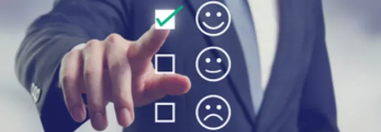 Persona en traje presionando un icono de cara sonriente en una pantalla.